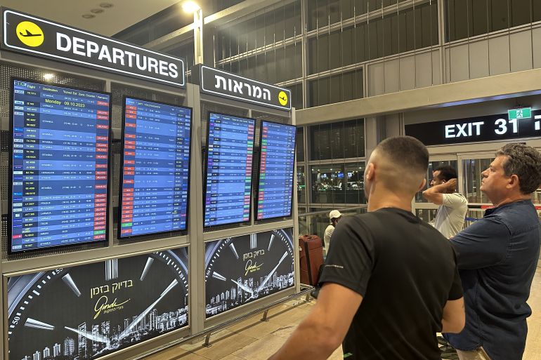 TEL AVIV, ISRAEL - OCTOBER 8: People look at the board showing departure schedules at Ben Gurion Airport, Israel's only international airport, after many flights from abroad are cancelled due to the attacks launched by Palestinian factions in Tel Aviv, Israel on October 8, 2023. ( Turgut Alp Boyraz - Anadolu Agency )