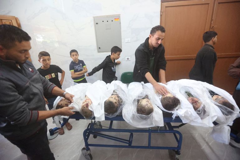 SENSITIVE MATERIAL. THIS IMAGE MAY OFFEND OR DISTURB People look at the bodies of 7 Palestinian children from Al-Bakri family, who health officials said were killed by an Israeli strike on their house, at a hospital in Khan Younis in the southern Gaza Strip October 19, 2023. REUTERS/Ahmed Zakot