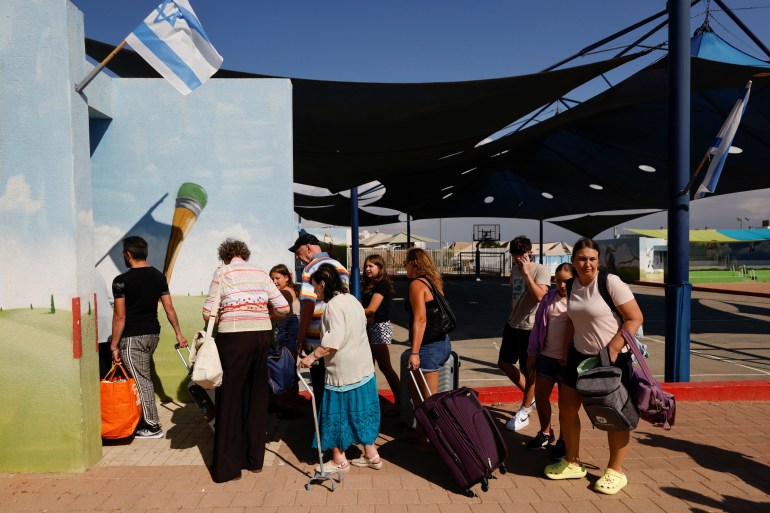 People queue as Israelis are evacuated from the southern town of Sderot, near Israel's border with Gaza, October 15, 2023. REUTERS/Amir Cohen