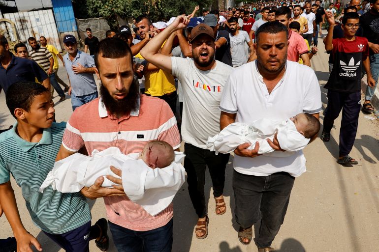 SENSITIVE MATERIAL. THIS IMAGE MAY OFFEND OR DISTURB Mourners carry the bodies of twin Palestinian babies Ossayd and Mohammad Abu Hmaid, who health officials said were killed along with their mother and three sisters in Israeli strikes, during their funeral in Khan Younis in the southern Gaza Strip October 8, 2023. REUTERS/Ibraheem Abu Mustafa
