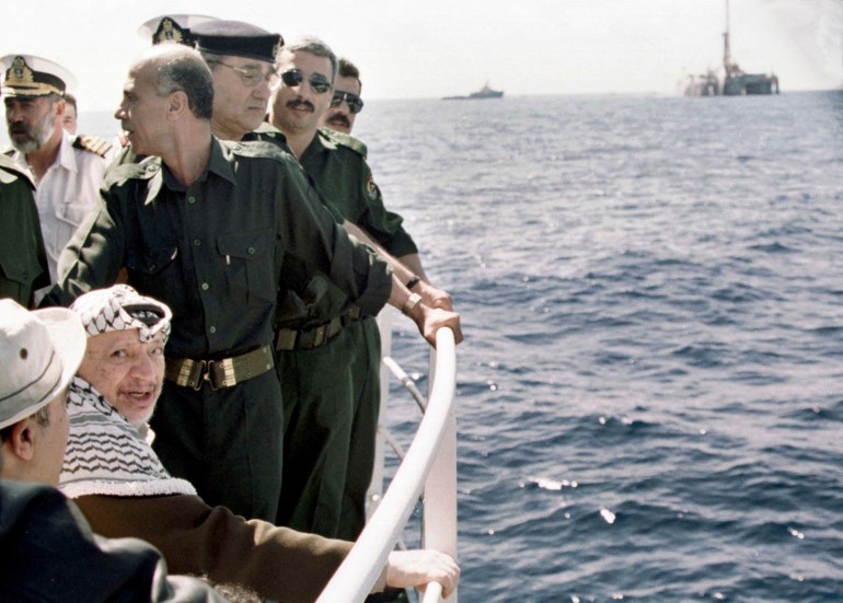 Palestinian leader Yasser Arafat(2nd L) boards a vessel during the official launching of drilling operations 27 September 2000 to tap a newly-discovered gas field off the coast of Gaza. British Gas (GB), which won a concession in 1999 to prospect in the Mediterranean off the Gaza Strip, invested 20 million dollars in the project. The southerly field is due to start commercial production around the end of 2002. (Photo by AP / POOL / AFP)