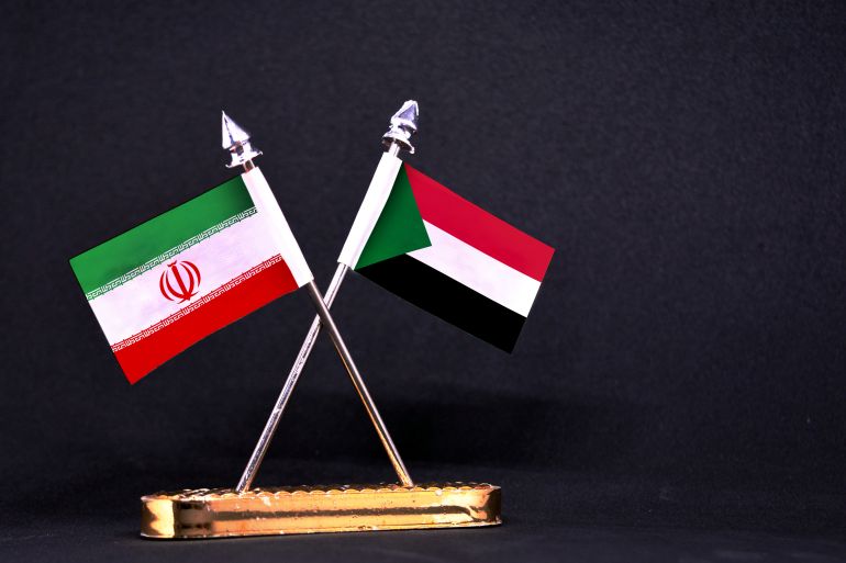 Iran and Sudan table flag with black Background; Shutterstock ID 1182420520; purchase_order: aljazeera ; job: ; client: ; other: