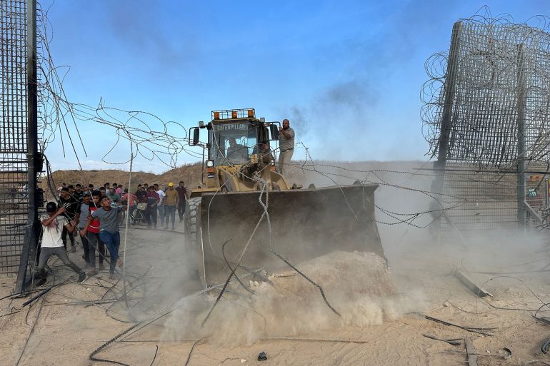 Palestinians break into the Israeli side of Israel-Gaza border fence after gunmen infiltrated areas of southern Israel, October 7, 2023. REUTERS/Mohammed Fayq Abu Mostafa NO RESALES. NO ARCHIVES.