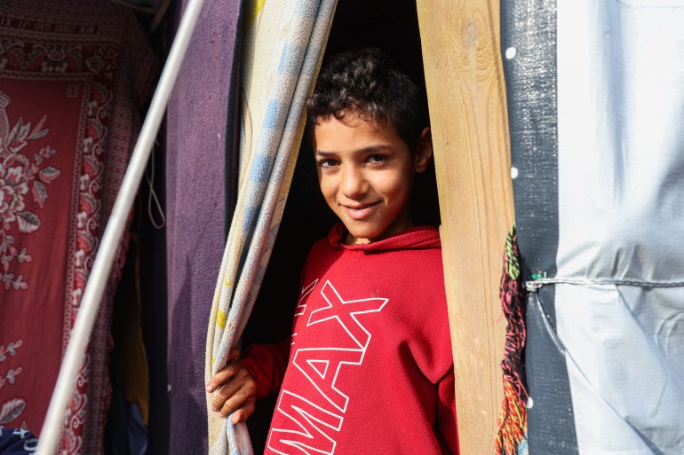: أحد أطفال النازح زاهر الريس يقف أمام خيمته