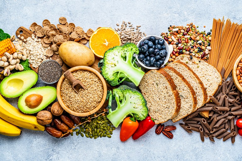 Overhead view of a large group of food with high content of dietary fiber arranged side by side. The composition includes berries, oranges, avocado, chia seeds, wholegrain bread, wholegrain pasta, whole wheat, potatoes, oat, corn, mixed beans, brazil nut, sunflower seeds, pumpkin seeds, broccoli, pistachio, banana among others. High resolution 42Mp studio digital capture taken with SONY A7rII and Zeiss Batis 40mm F2.0 CF lens