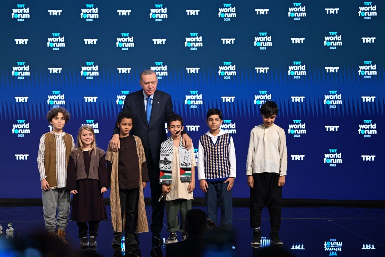 ISTANBUL, TURKIYE - DECEMBER 08: Turkish President Recep Tayyip Erdogan (C) poses for a photo with children who present the 'Key of Peace' to him as a gesture of gratitude for his unwavering commitment to global peace within the opening ceremony of the 'TRT World Forum 2023,' which convened academics, journalists, politicians, and non-governmental organizations for the seventh consecutive year at Hilton Bomonti Hotel, in Istanbul Turkiye on December 08, 2023. TRT World Forum, which will be organized for the seventh time this year, is initiated under the theme 'Thriving Together: Responsibilities, Actions, and Solutions'. (Photo by Emrah Yorulmaz/Anadolu via Getty Images)
