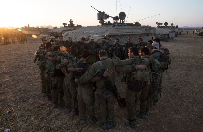 Israeli soldiers from the Golani Brigade stand in a circle at a staging area before entering Gaza from Israel July 30, 2014. Israeli fire killed at least 43 Palestinians in the Gaza Strip early on Wednesday as the Jewish state said it targeted Islamist militants at dozens of sites across the coastal enclave, while Egyptian mediators prepared a revised ceasefire proposal. REUTERS/Baz Ratner (ISRAEL - Tags: CIVIL UNREST CONFLICT MILITARY POLITICS TPX IMAGES OF THE DAY)