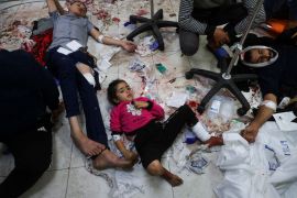 جرحى يرقدون على الأرض في مستشفى ناصر، في أعقاب الغارات الإسرائيلية على مدرسة معان شرق خان يونس.. صورة كاشفة عن فشل الإنسانية في غزة (رويترز)