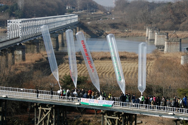 Former North Korean defectors and anti-North Korea activists release balloons with anti-North Korea leaflets towards the North in Imjinkak pavilion, near the demilitarised zone (DMZ) separating the two Koreas in Paju, about 55 km (34 miles) north of Seoul, December 3, 2008. Dozens of activists, who demanded improvements of North Korea's human rights and the release of South Koreans abducted by the North, launched about 90,000 anti-Pyongyang leaflets in helium-filled balloons near the DMZ on Wednesday. REUTERS/Lee Jae-Won (SOUTH KOREA)