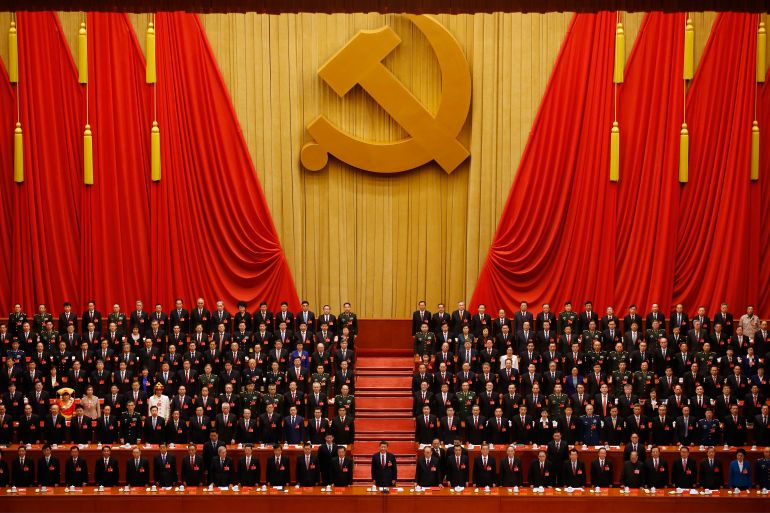 FILE - Chinese President Xi Jinping, front row center, stands with his cadres during the Communist song at the closing ceremony for the 19th Party Congress at the Great Hall of the People in Beijing on Oct. 24, 2017. China's long-ruling Communist Party on Tuesday, Aug. 30, 2022, set October 16 for its 20th party congress, at which leader Xi is expected to be given a third five-year term. (AP Photo/Ng Han Guan, File)