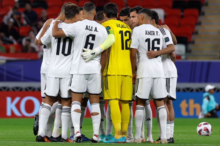 Iraq's players stand in a huddle before the start of the Qatar 2023 AFC Asian Cup Group D football match between Indonesia and Iraq at the Ahmad bin Ali Stadium in Al-Rayyan, west of Doha on January 15, 2024. (Photo by KARIM JAAFAR / AFP)