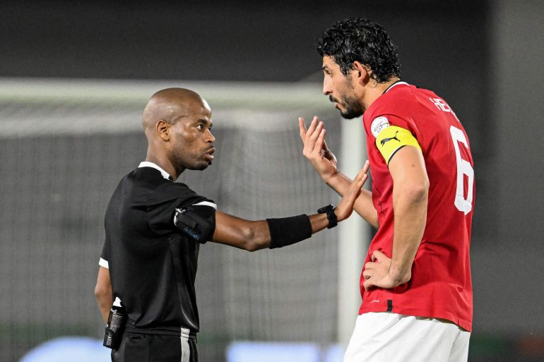 Egypt's defender #6 Ahmed Hegazy (R) speaks with South African referee Abongile Tom during the Africa Cup of Nations (CAN) 2024 round of 16 football match between Egypt and DR Congo at the Stade Laurent Pokou in San Pedro on January 28, 2024. (Photo by SIA KAMBOU / AFP)
