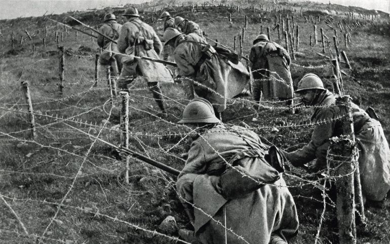 World War 1: Battle of Verdun. French soldiers crawling through their own barbed wire entanglements as they begin an attack on enemy trenches. April-June, 1916.
