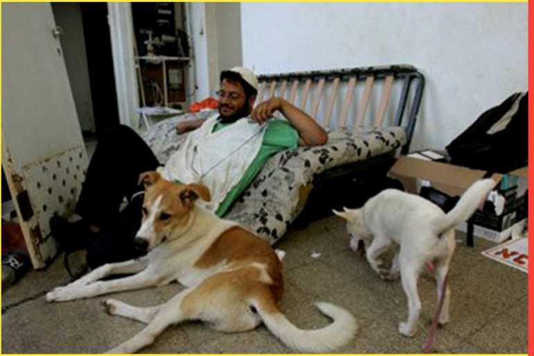 Israeli settler Itamar Ben Gvir enjoys a break with his dogs at the Palm Beach Hotel, where dozens of right-wing Israelis have set up base in a bid to thwart the operation to withdraw from the occupied Palestinian territory that is to begin in mid-August, 24 June 2005