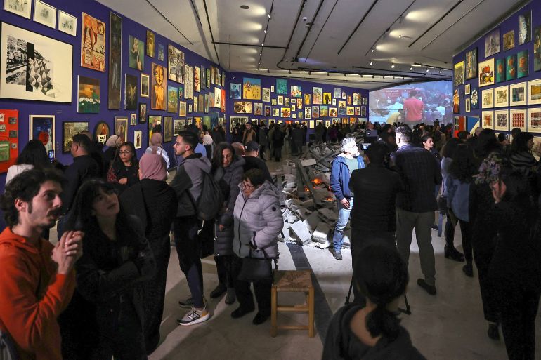 People visit the 'This Is Not An Exhibition' section displaying paintings by Gazan artists, as the Palestinian Museum reopened in Birzeit town in the occupied West Bank on February 11, 2024. - The museum reopened following closure in the aftermath of the October 7 attacks and ensuing conflict with Israel, with several exhibits showcasing Gazan art and heritage from collections and individuals in the West Bank. (Photo by Zain JAAFAR / AFP)
