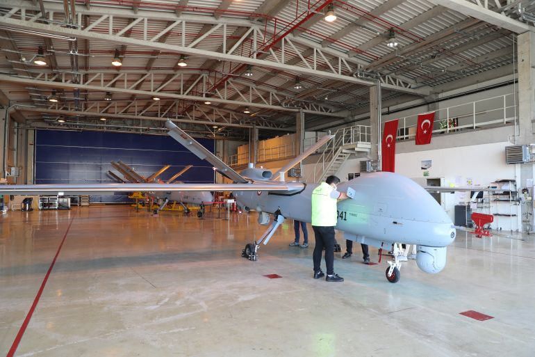 The Anka Drone, 8.6 metres long and with a wingspan of 17.6 metres, manufactured in Turkish Aerospace's huge, ultra-secure facilities in Ankara which cover 4 million square metres of hangars where 10,000 people, including 3,000 engineers are employed is checked by employees in Ankara on March 5, 2021. (Photo by Adem ALTAN / AFP)