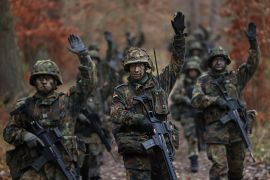 PRENZLAU, GERMANY - NOVEMBER 29: New army (Heer) recruits of the Bundeswehr, Germany's armed forces, signal while on patrol during basic training in a forest on November 29, 2022 near Prenzlau, Germany. German Chancellor Olaf Scholz, following Russia's invasion of Ukraine, pledged to create a special fund of EUR 100 billion to invest in Germany's armed forces, which will go to both high tickets investments like modern attack aircraft and transport helicopters but also into improved preparedness of existing equipment. (Photo by Sean Gallup/Getty Images)
