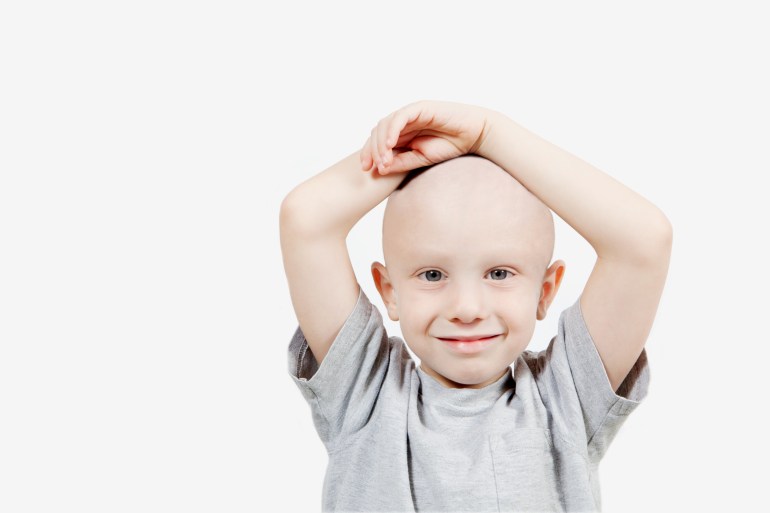 Depiction of happy child with the effects of chemotherapy. On white background, horizontal composition. Copy Space.