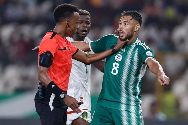 Somalian referee Omar Abdulkadir Artan (left) gets to grips with Algeria’s Youcef Belaili.