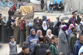 فلسطينيون ينتظرون استلام كميات من الدقيق والمساعدات في غزة (وكالة الأناضول)