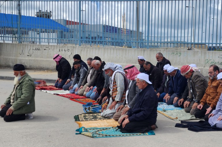 صورة 1- فلسطين- رام الله- عزيزة نوفل- فلسطينيين يؤدون صلاة الظهر الجمعة الأولى من رام الله أمام حاجز قلنديا بعد منعهم الدخول للأقصى- الجزيرة