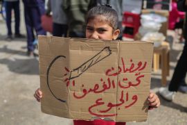 أطفال فلسطينيون يحملون لافتات خلال مسيرة تطالب بإنهاء الحرب ووضع حد للمجاعة (غيتي)