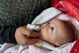 فلسطينية تطعم مولودها تمرا مع انعدام المواد الغذائية خاصة في شمال غزة (رويترز)