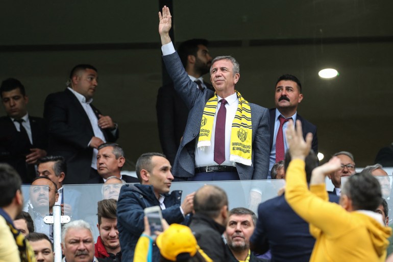 Turkey's main opposition Republican People's Party (CHP) and new mayor of Ankara Mansur Yavas (C) gestures during the Turkish Super Lig football match between Ankaragucu and Fenerbahce at Eryaman Stadium in Ankara on April 7, 2019. (Photo by Adem ALTAN / AFP)