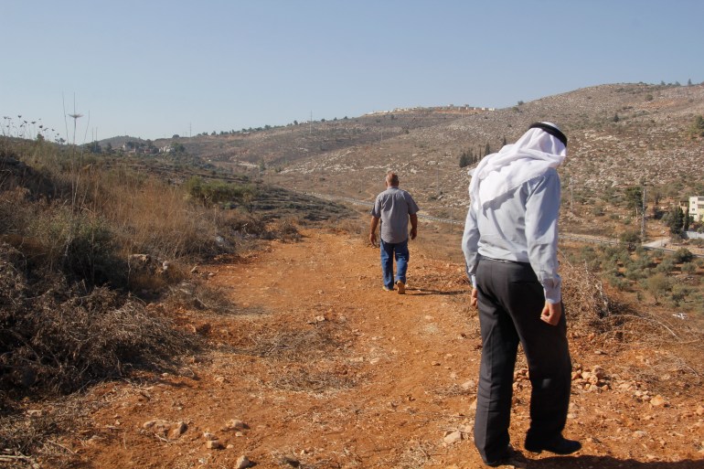 عاطف دغلس- المواطن محمد ضميدي ووالده يسيران في الطريق الاستيطاني الذي شقه الاحتلال في ارضهم- الضفة الغربية- نابلس- جنوب المدينة- الجزيرة نت9