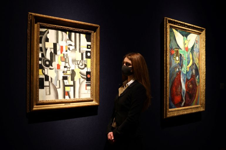 A gallery assistant poses by an artwork titled 'Composition' by Fernand Leger ahead of "20th / 21st Century and Art of the Surreal Evening Sale" auction at Christie's in London, Britain, February 23, 2022. REUTERS/Tom Nicholson
