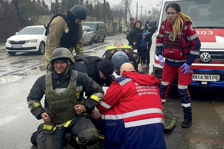 EDITORS NOTE: Graphic content / This handout photograph taken and released by Ukrainian Emergency Service on March 15, 2024 shows rescuers and medical staff providing assistance to an injured rescuer following a missile attack in Odesa. - Ukrainian authorities said on March 15, 2024 that the death toll from a Russian strike on the Black Sea port city of Odesa had grown to 14 with dozens more injured. (Photo by Handout / UKRAINIAN EMERGENCY SERVICE / AFP) / RESTRICTED TO EDITORIAL USE - MANDATORY CREDIT "AFP PHOTO / UKRAINIAN EMERGENCY SERVICE" - NO MARKETING NO ADVERTISING CAMPAIGNS - DISTRIBUTED AS A SERVICE TO CLIENTS - RESTRICTED TO EDITORIAL USE - MANDATORY CREDIT "AFP PHOTO / UKRAINIAN EMERGENCY SERVICE" - NO MARKETING NO ADVERTISING CAMPAIGNS - DISTRIBUTED AS A SERVICE TO CLIENTS /