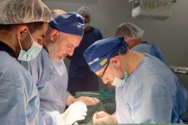 الطبيب التركي تانر كاماجي (يمين) يجري عملية لأحد المصابين في غزة (الجزيرة)