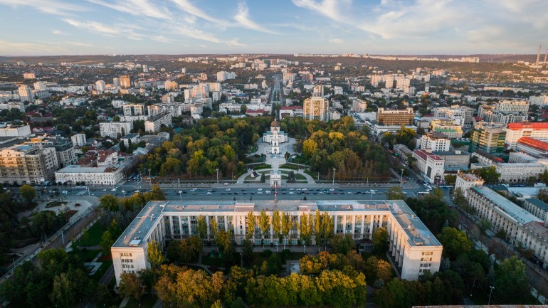 Aerial drone view of Chisinau downtown at sunset, Moldova. View of Central Park, Cathedral, Goverment and a lot of greenery, buildings, illumination