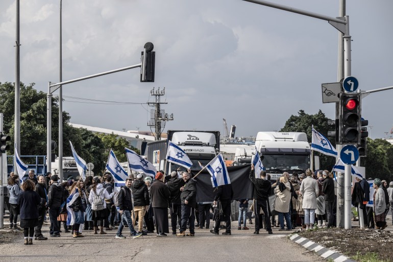 ASHDOD, ISRAEL - FEBRUARY 01: A group of Jewish, called 'Hill Youth' hold Israeli flags as they gather to stage a demonstration to prevent humanitarian aid being sent to Gaza near the port in Ashdod, Israel on February 01, 2024. (Photo by Mostafa Alkharouf/Anadolu via Getty Images)