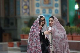 فتيات إيرانيات يلتقطن صورة لهن في ضريح إمام زاده صالح في طهران (رويترز)