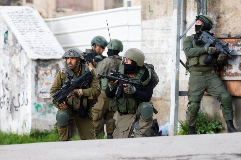 Israeli soldiers take position during a raid, in Ramallah, in the Israeli-occupied West Bank March 4, 2024. REUTERS/Mohammed Torokman