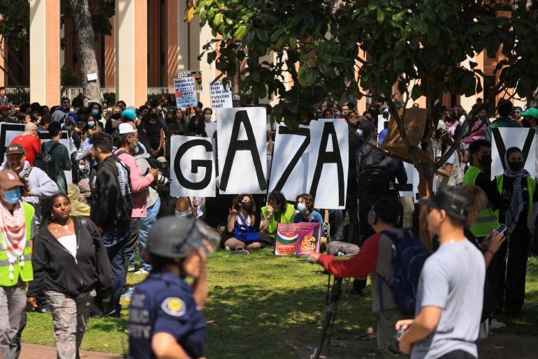 Demonstrators holding signs gather after students built a protest encampment in support of Palestinians at the University of Southern California's (USC) Alumni Park, during the ongoing conflict between Israel and the Palestinian Islamist group Hamas, in Los Angeles, California, U.S., April 24, 2024. REUTERS/David Swanson
