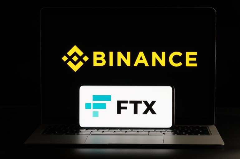 Binance and FTX Cryptocurrency Exchange merger concept. FTX logo seen on smartphone and blurred Binance logo on the laptop. Stafford, United Kindom, November 9, 2022.; Shutterstock ID 2224660455; purchase_order: AJA; job: ; client: ; other: