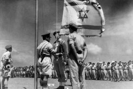 A picture released on June 8, 1948 shows an Israeli officer raising the National Flag for the first time during the celebration of the birth of the Israeli State after its proclamation, on May 14, 1948. [INTERCONTINENTALE/AFP via Getty Images] (AFP)