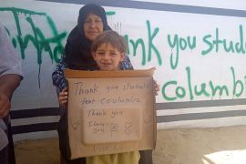 الطفل نبيل معروف في رفح يرفع لافتة شكر لطلبة جامعة كولومبيا لتضامنهم مع غزة (الجزيرة)