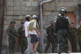 مستوطنون يهود في حماية قوات الاحتلال في الخليل بالضفة الغربية (وكالة الأناضول)