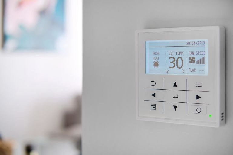 Concept of smart modern luxury wealthy home. On white wall home security alarm and video intercom, no people. Climate control system on a white wall close up