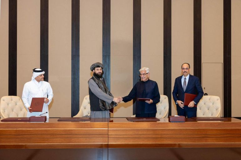 Afghan Defence Minister, Mullah Mohammad Yaqoob Mujahid and Pakistan's Defence Minister, Khawaja Muhammad Asif shake hands, following the signing of a ceasefire agreement, during a negotations meeting mediated by Qatar and Turkey, in Doha, Qatar, October 19, 2025. Qatar Ministry Of Foreign Affairs/Handout via REUTERS THIS IMAGE HAS BEEN SUPPLIED BY A THIRD PARTY. MANDATORY CREDIT. NO RESALES. NO ARCHIVES.
