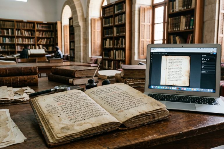 بين رفوف المكتبات والأرشيفات العربية، تنتظر آلاف الكتب والمخطوطات والوثائق انتقالها من ذاكرة محفوظة على الورق إلى بيانات تستطيع الآلات قراءتها وفهرستها وتحليلها.(مولدة بالذكاء الاصطناعي/الجزيرة)