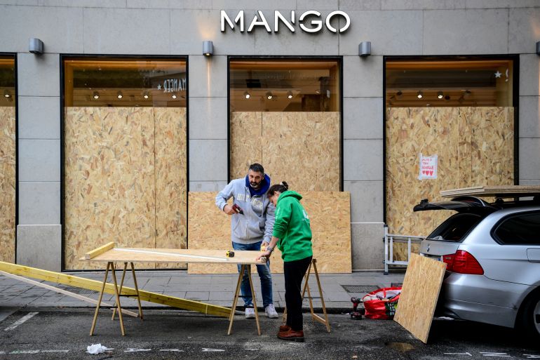 Workers prepare plywood boards to install on a shop window in Lyon, on October 23, 2026 ahead of protests. France will deploy some 70,000 security personnel nationwide for new protests this weekend, Interior Minister said on October 23, warning that calls for violence and looting were already circulating on social media. (Photo by OLIVIER CHASSIGNOLE / AFP)
