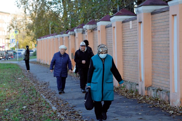 A woman wearing a face mask walks past the anti-plague institute in the city of Irkutsk on October 7, 2026.