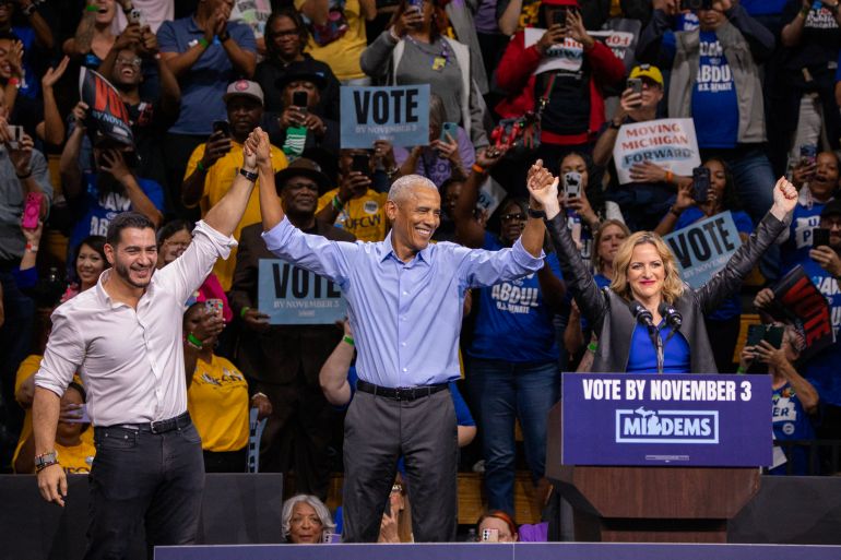 Former US President Barack Obama (C), Democrat Michigan senatorial candidate Abdul El-Sayed (L) and Michigan Secretary of State and Democrat gubernatorial candidate Jocelyn Benson (R) raise joined hands as they campaign together with other Michigan Democratics at a rally in Detroit, Michigan on October 24, 2026. (Photo by Bill Pugliano / AFP)