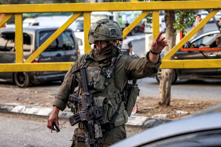 Israeli army soldiers close the vehicle barrier at the Deir Sharaf checkpoint, west of Nablus in the Israeli-occupied West Bank, on October 25, 2026.