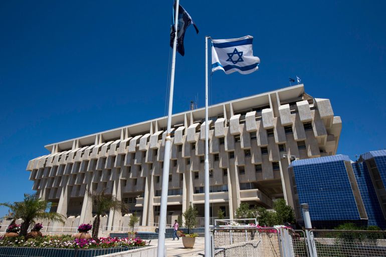 An Israeli flag flutters outside the Bank of Israel building in Jerusalem August 7, 2013. Prime Minister Benjamin Netanyahu was starting a meeting with his team of Middle East peace negotiators last week when Leo Leiderman, his second choice to lead the Bank of Israel, called. Just 48 hours earlier, on July 31, Leiderman had agreed to replace central bank governor Stanley Fischer, who once taught U.S. Federal Reserve Chairman Ben Bernanke and whose reputation had lifted Israel's international economic profile. Leiderman, the second nominee to drop out in less than a week, had changed his mind for undisclosed personal reasons, raising questions not only over Netanyahu's judgment but also much wider concerns about Israel's economic management. Picture taken August 7, 2013. REUTERS/Ronen Zvulun (JERUSALEM - Tags: POLITICS BUSINESS)