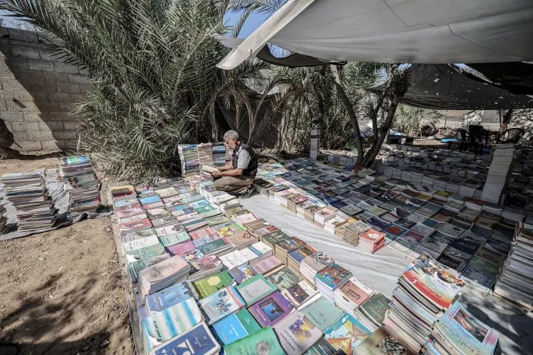 محمد سعد يفرز الكتب داخل خيمة في دير البلح بغزة